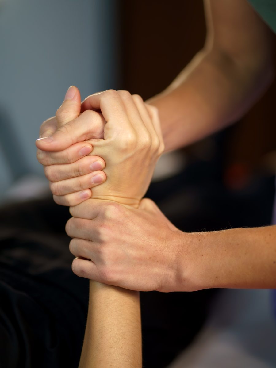 Primo piano delle mani di Irene che accompagnano il polso di una persona